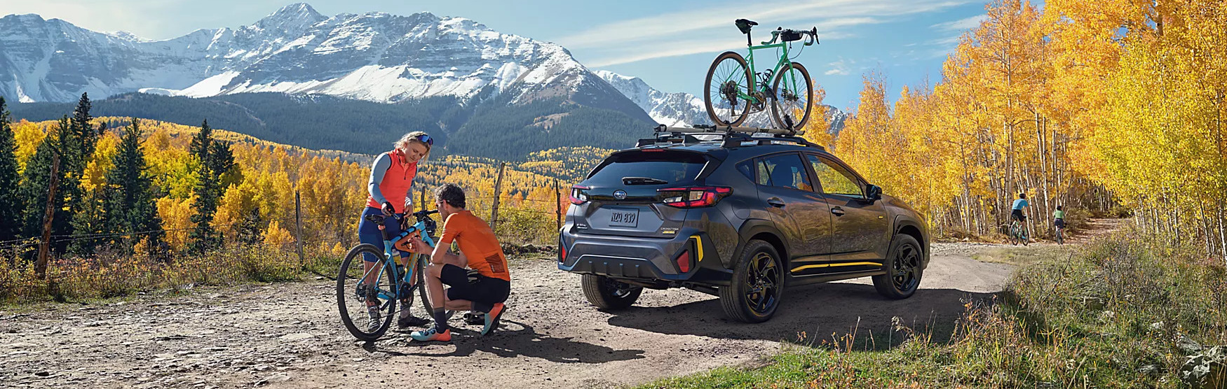 2025 subaru crosstrek parked on a trail with people headed to a bike trail in the mountains.