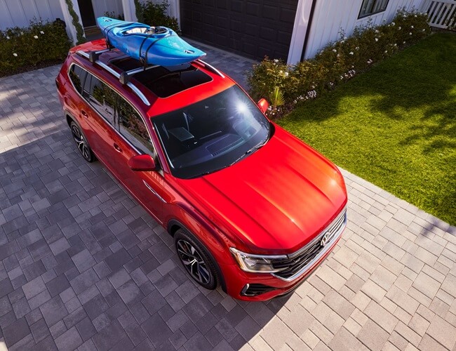 Birdseye view of red Volkswagen with a kayak on the roof