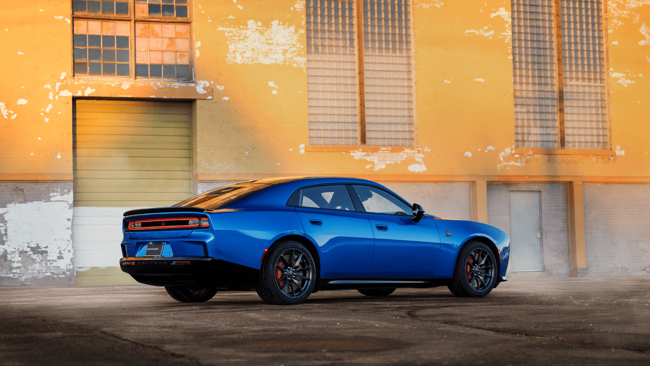 2026 Dodge Charger Daytona in bright blue parked with retro-inspired muscle car styling.