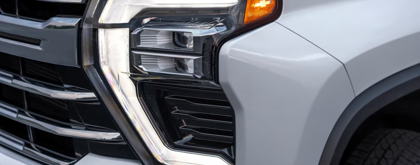 Headlight and grille on a white 2025 Chevy Silverado 3500 HD