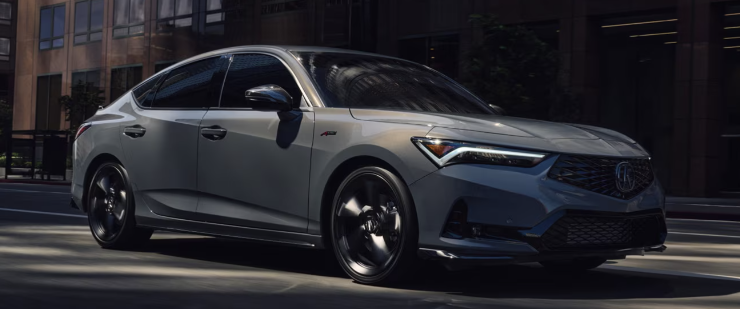 2026 Acura Integra driving on city street showing side view