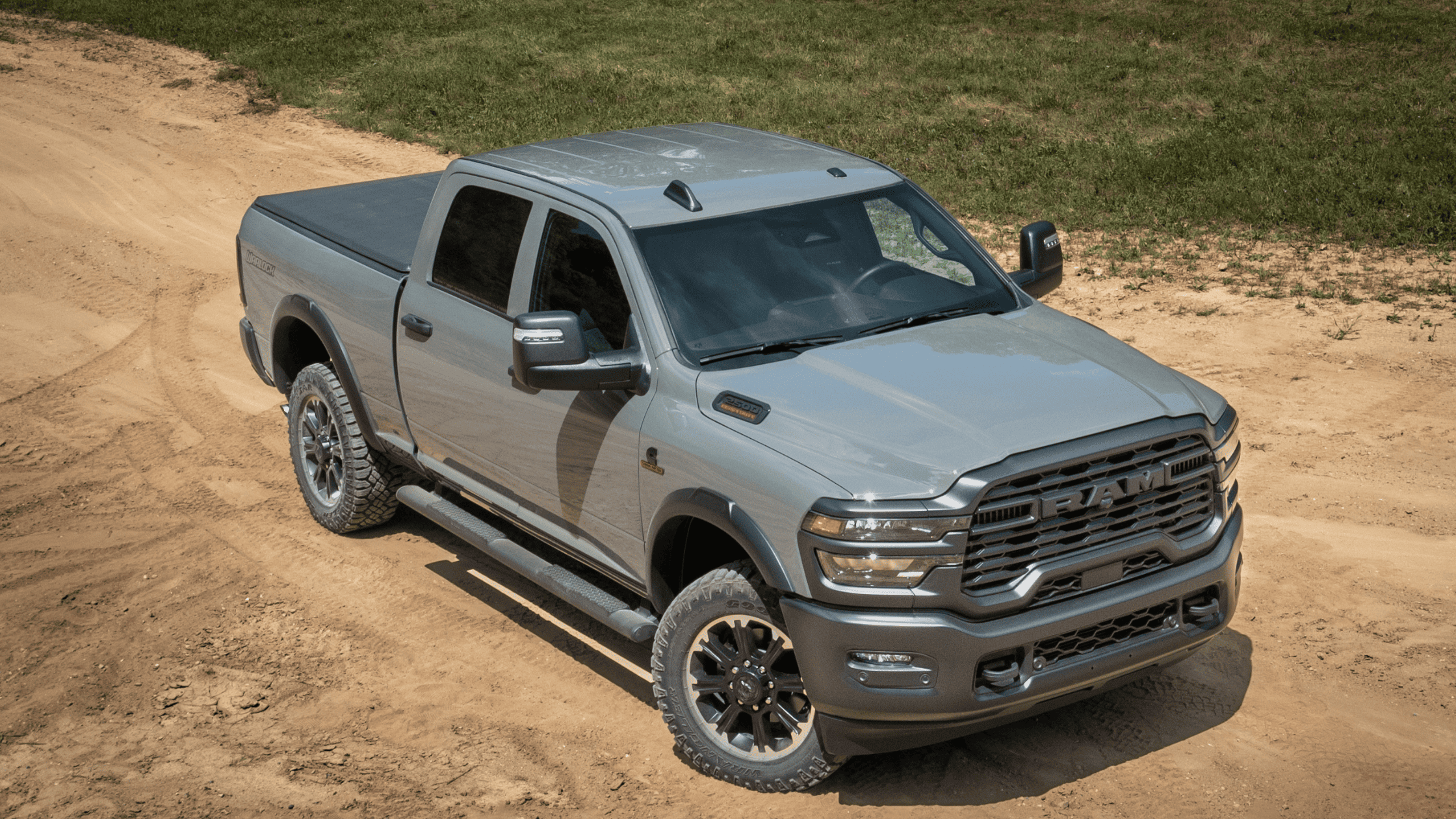 Aerial view of 2026 Ram Heavy Duty truck in gray on dirt terrain highlighting robust off-road capability.