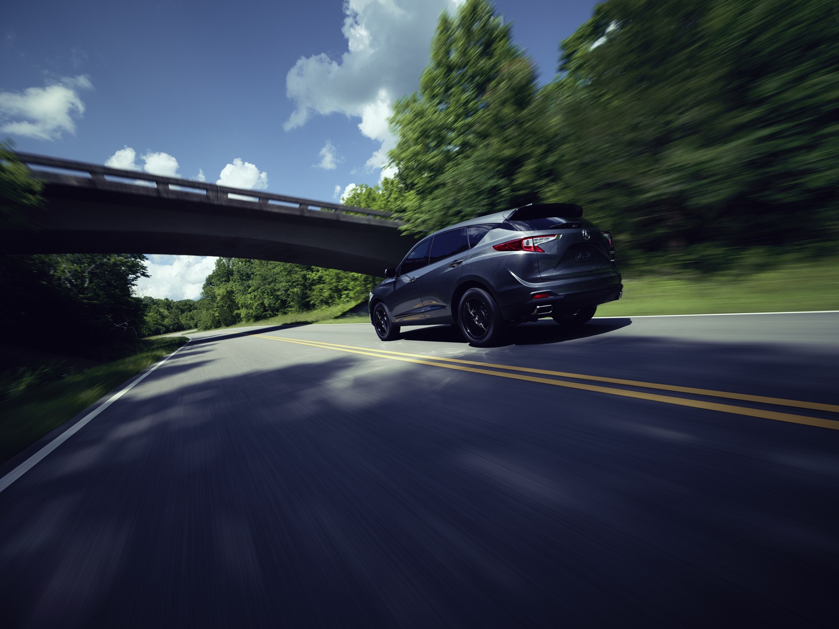 Acura driving under overpass