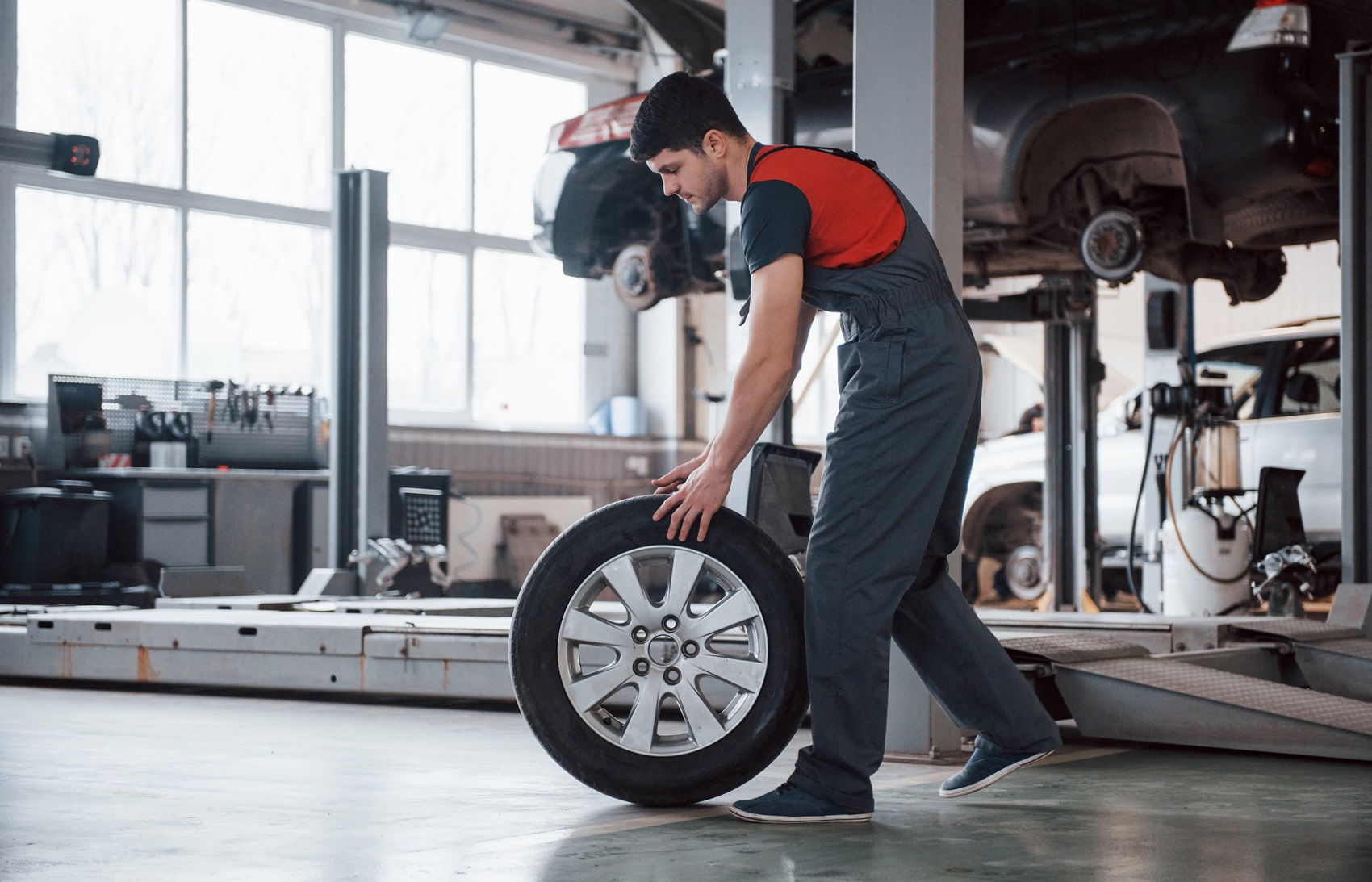 Service technician pushing tire along the floor 
