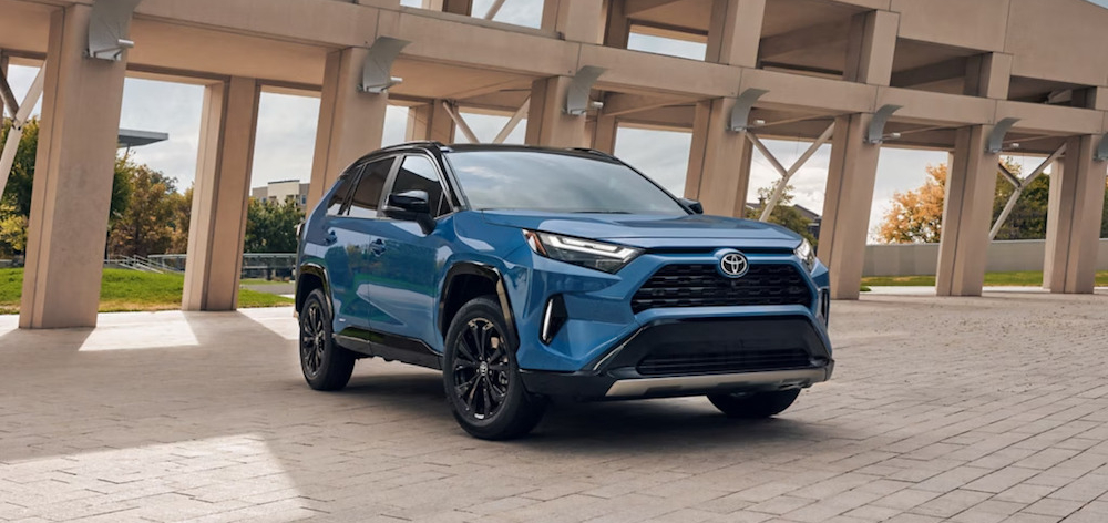 A blue 2025 Toyota RAV4 Hybrid XSE parked in front of a concrete structure