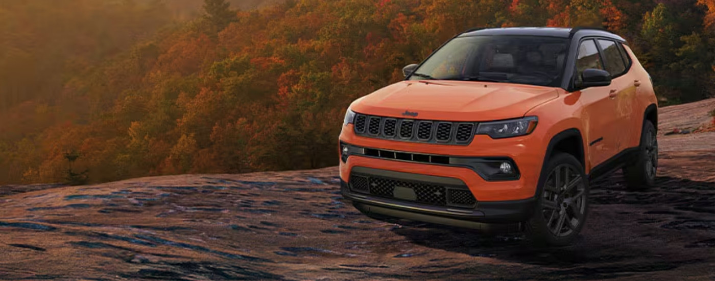An orange 2025 Jeep Compass for sale from the front at an angle.
