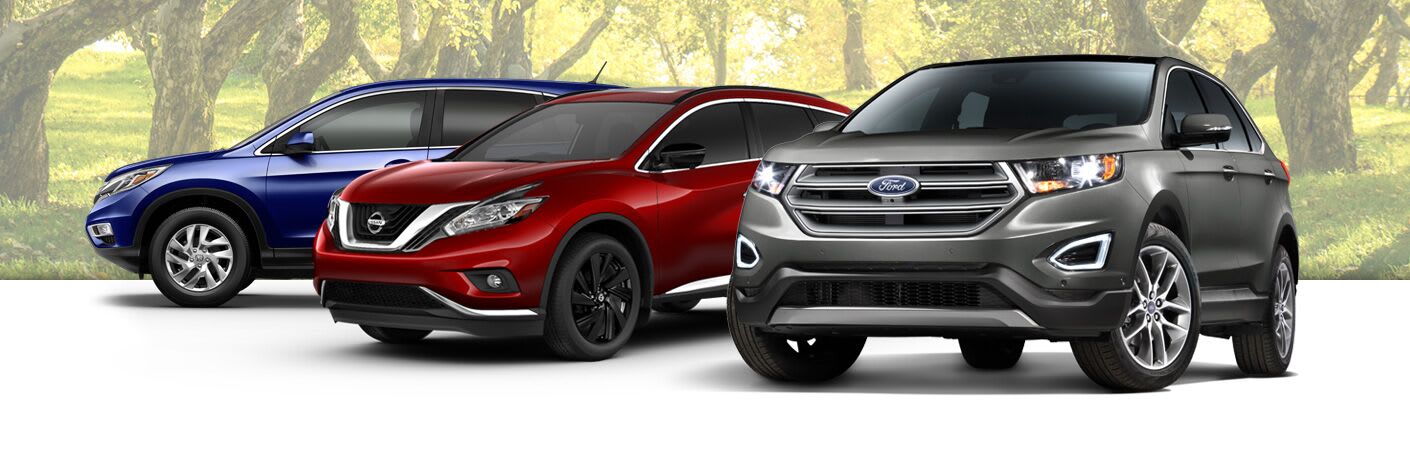 Three SUVs from different automakers against a backdrop of trees.