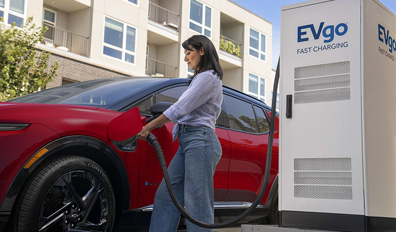 Woman charging 2024 Chevy Equinox EV outside Woman charging 2024 Chevy Equinox EV outside