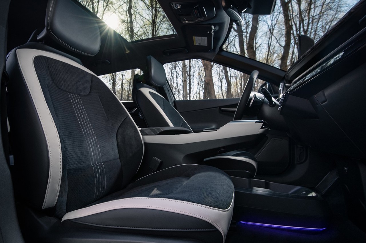 Interior Side view of the front seats that are black with light gray trim and the console