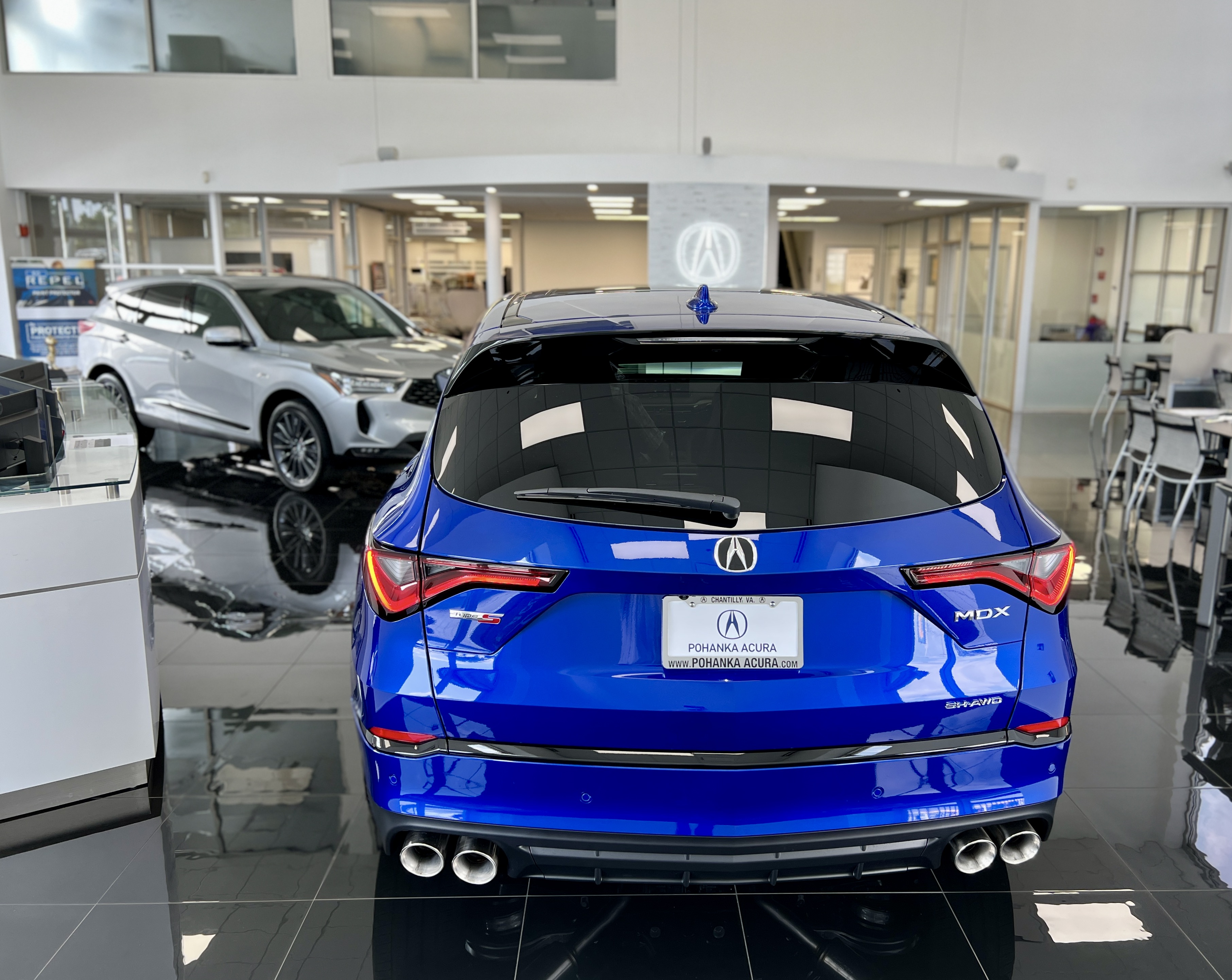 Rear view of Blue Acura sitting in a showroom