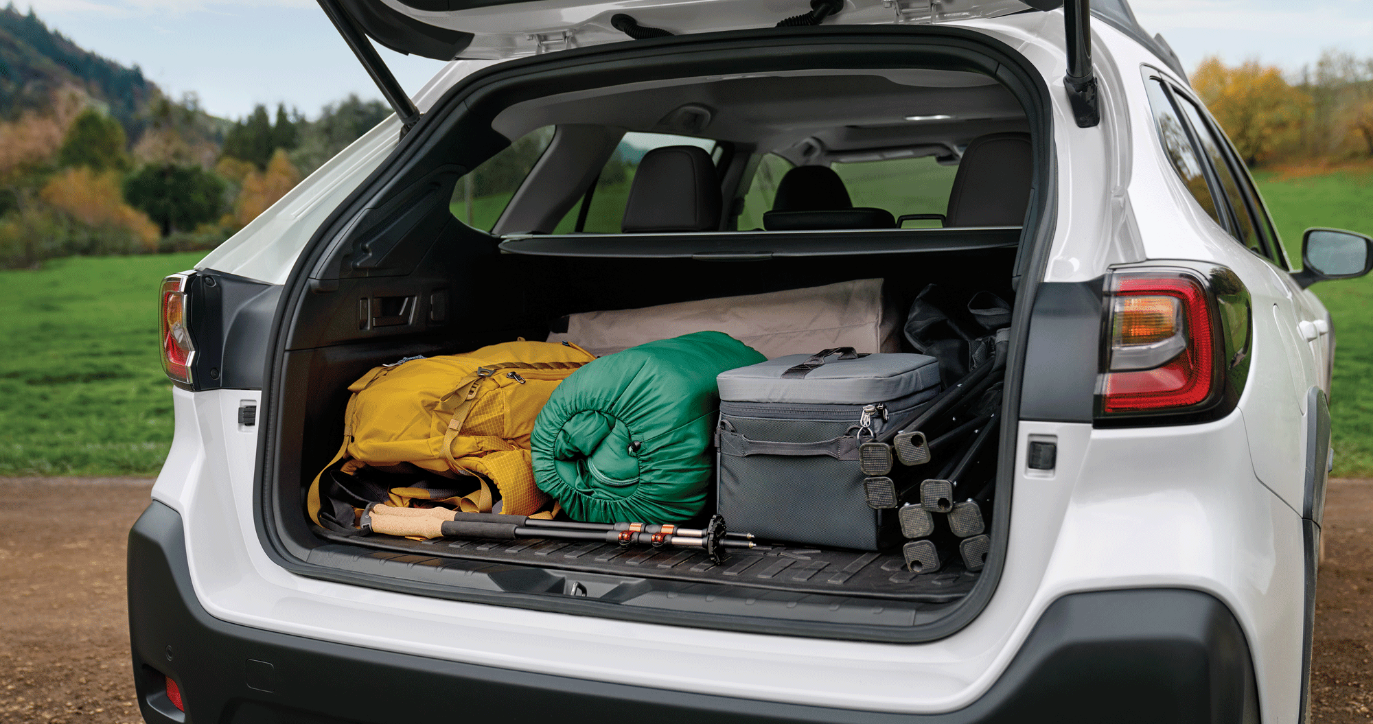 A view of the open rear cargo area of the 2023 Outback loaded with gear.
