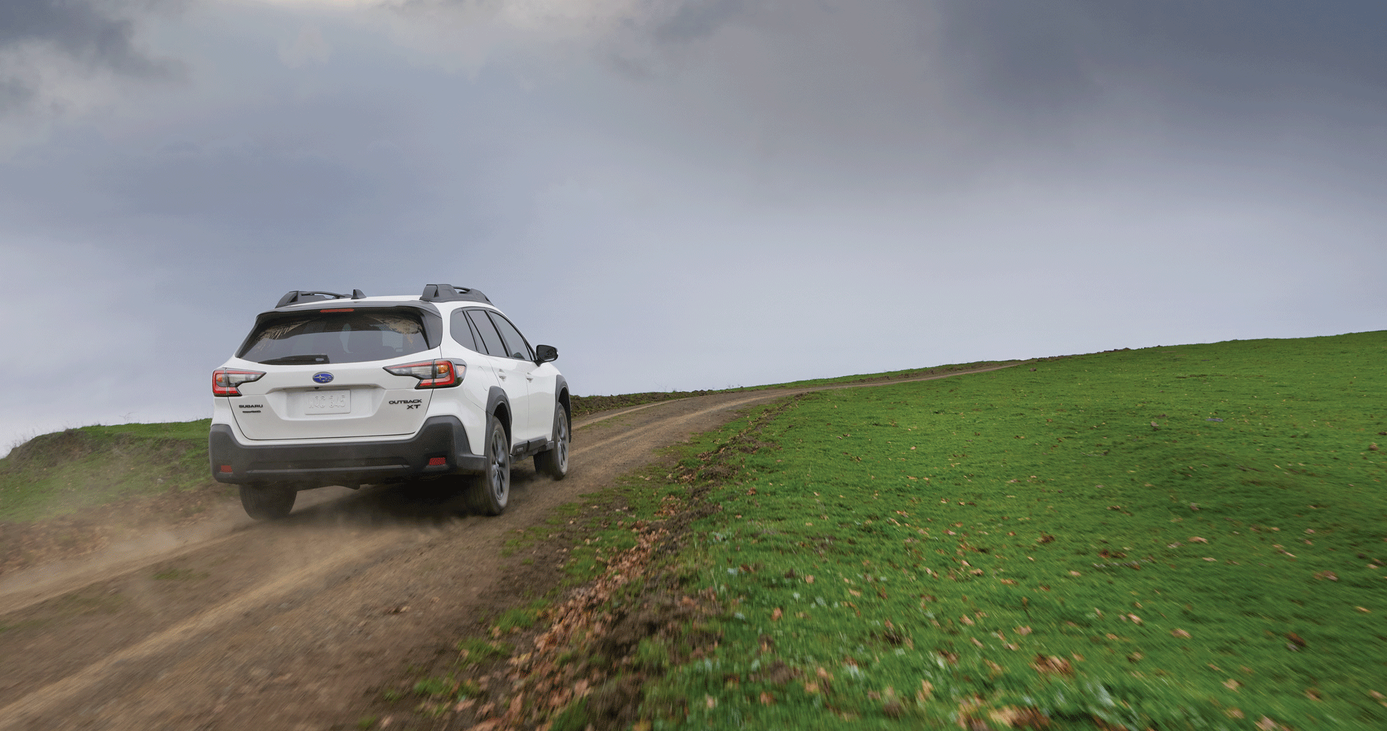  A 2023 Outback Onyx Edition driving on a dirt road.
