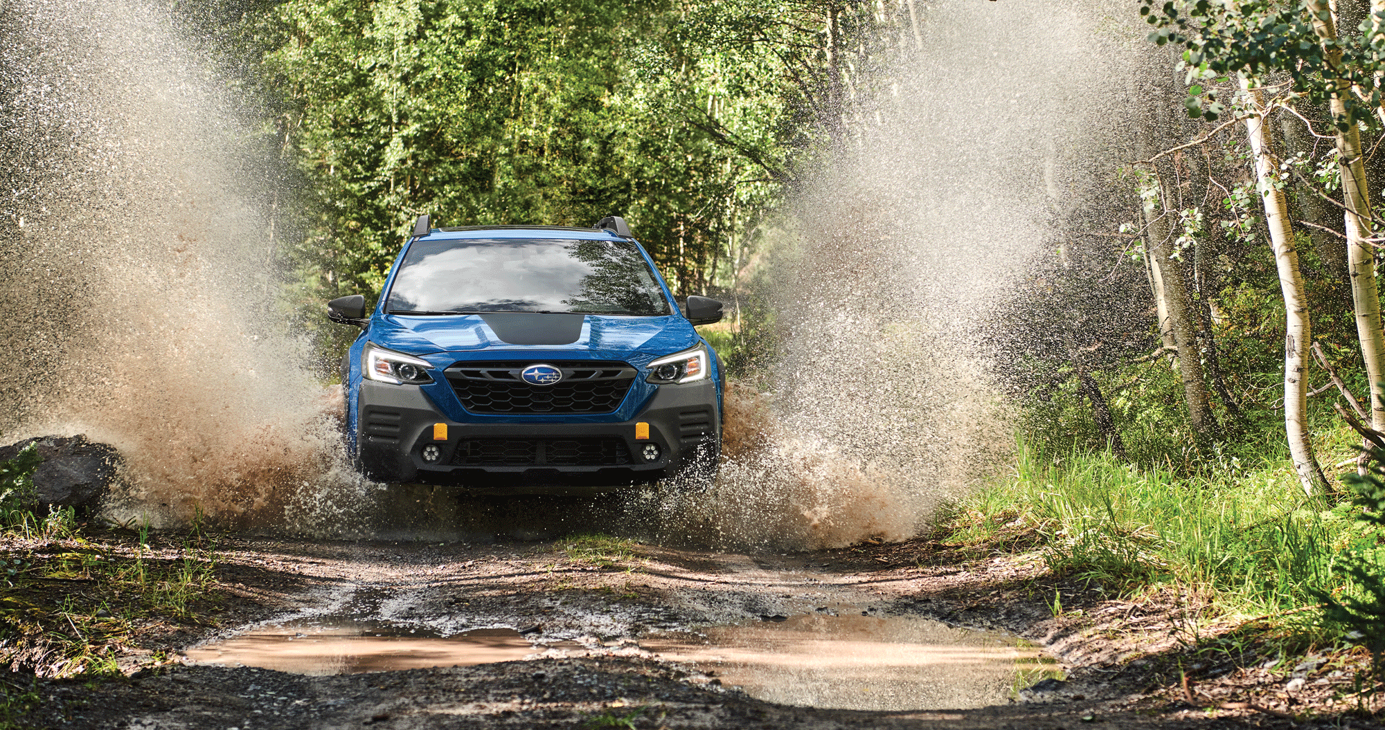 A 2023 Outback Wilderness driving down a muddy trail.