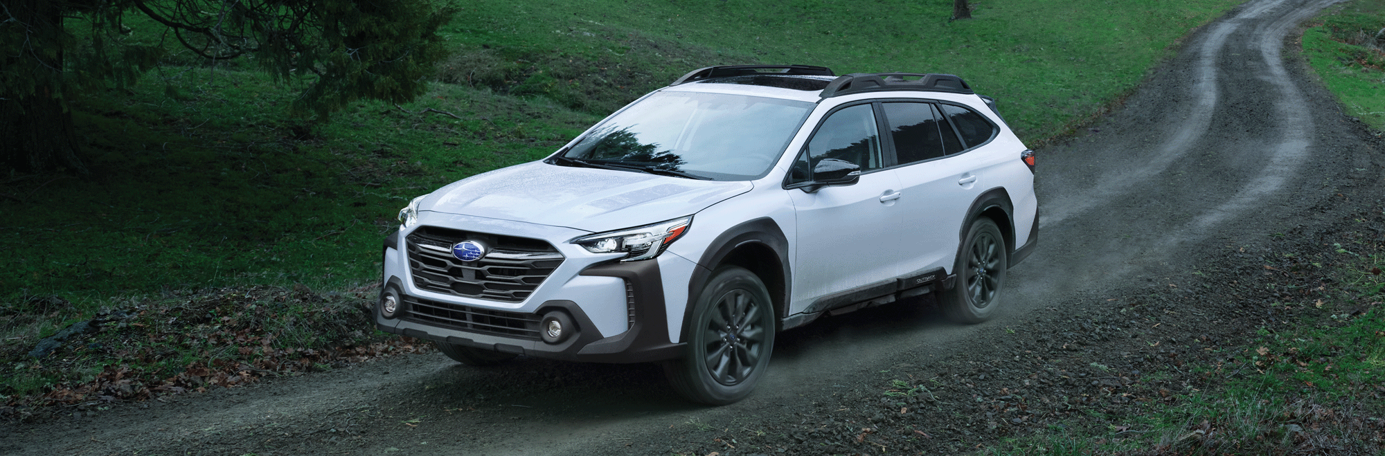 A 2023 Outback driving on a dirt road.
