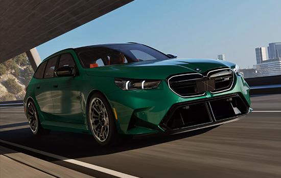 Green BMW M5 Touring driving on a city road.