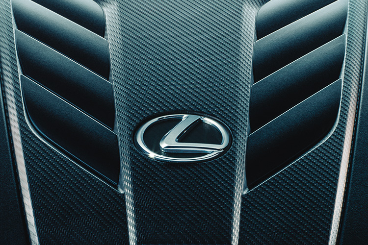 Close up of an engine featuring the Lexus emblem.