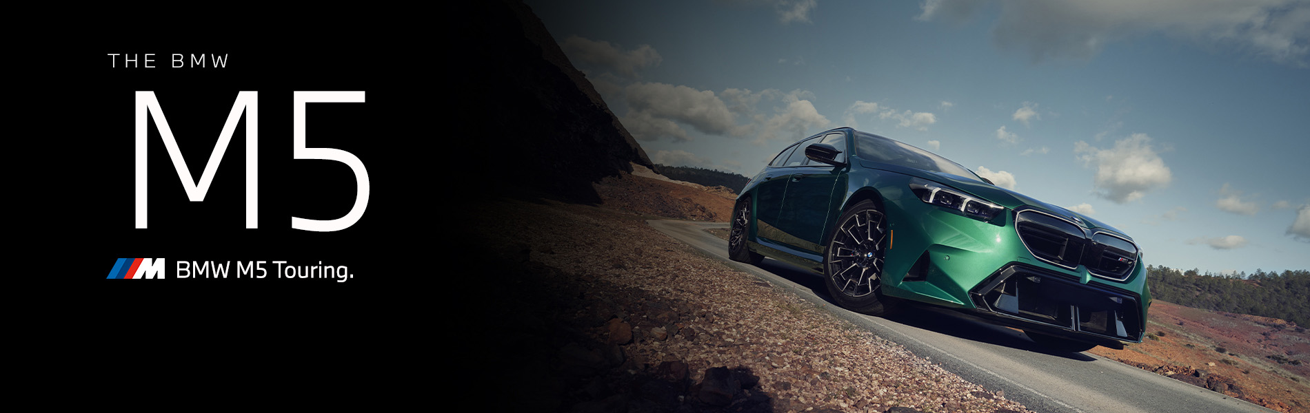 The BMW M5 Touring in green driving down desert road