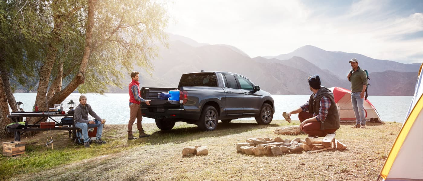 2020 Honda Ridgeline parked outside with a family camping