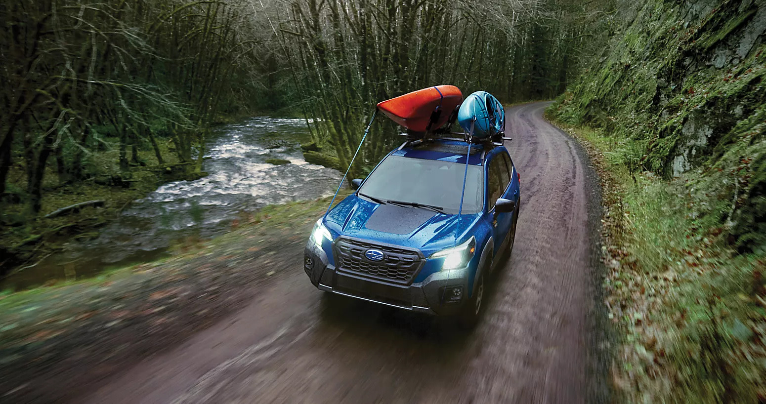 the 2025 forester driving on a dirt path in the woods
