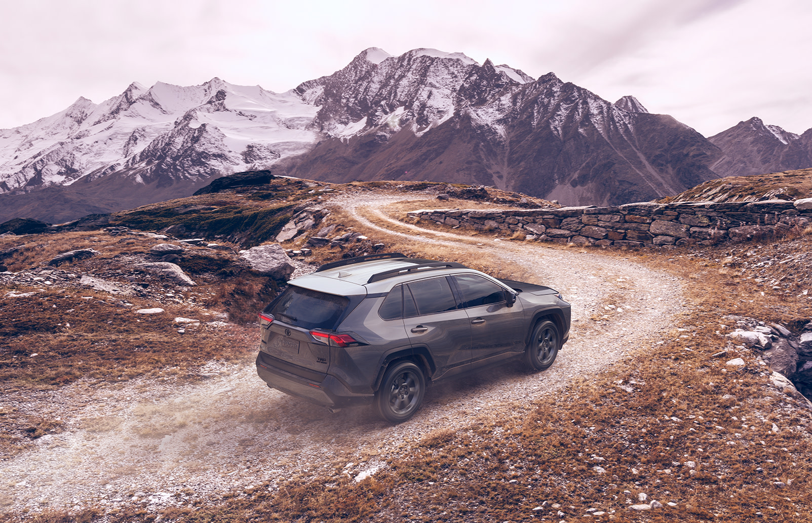 Compare the 2020 Toyota RAV4 vs. the Honda CR-V crossovers at Tri County Toyota | grey 2020 rav4 driving up the hill