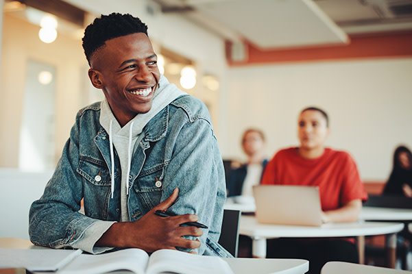Student smiling at desk.