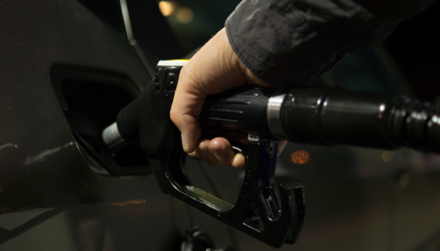 Close-up of a hand using a gas pump to refuel a car