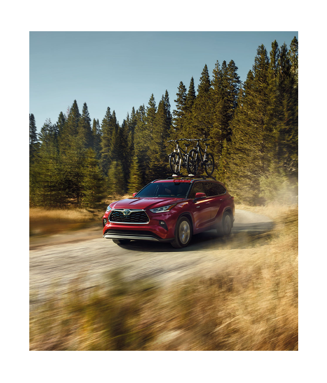 2024 Toyota Highlander vs. 2024 Honda Pilot at Tri County Toyota | Red 2024 Toyota Highlander driving fast down a dirt road 