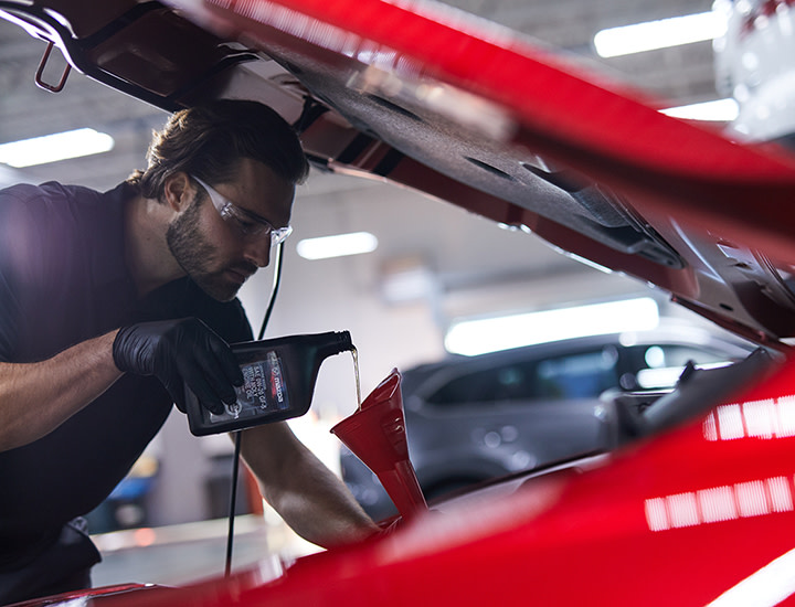 Parked Grey Mazda on a road with a orange sunset sky in the background
