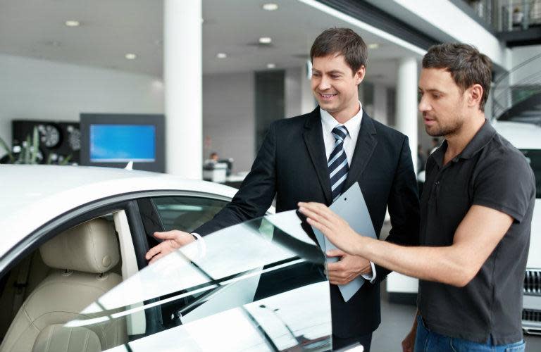salesman showing car to man