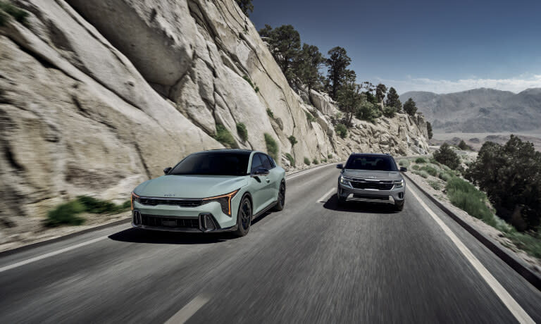 Two 2025 Kia K4s driving in the mountains