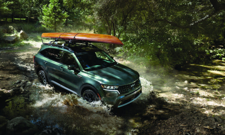 2025 Kia Sorento driving through stream with kayak