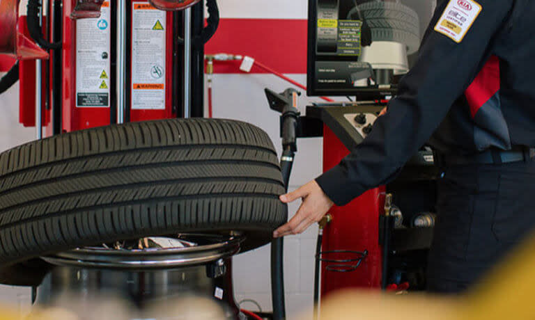 Kia technician checking a tire