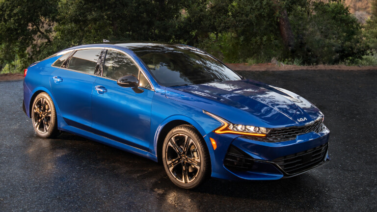 2026 Kia K5 parked on road by forest