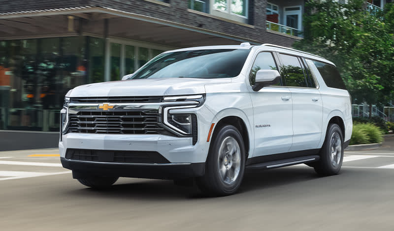 White 2025 Chevrolet Suburban driving on road